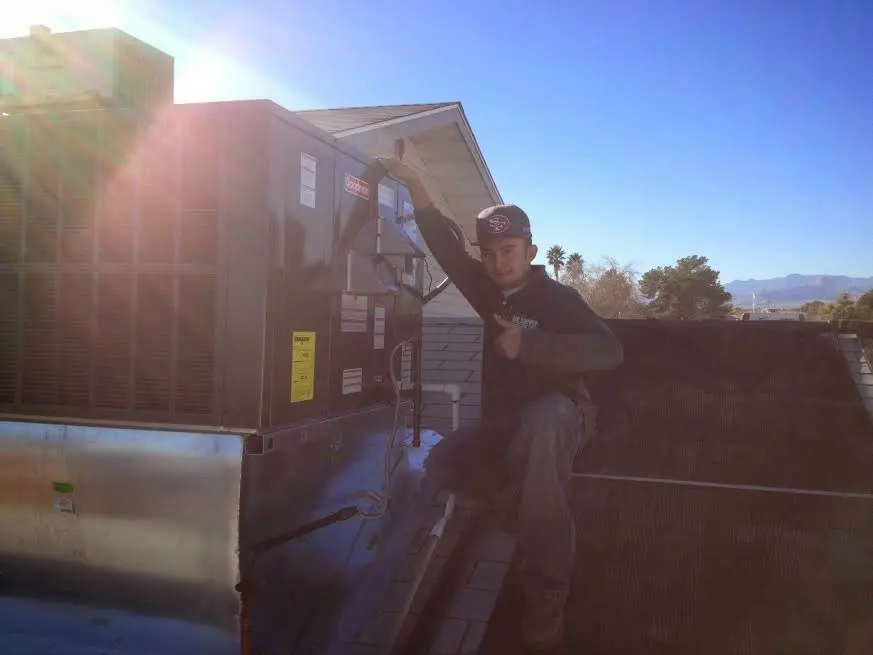 HVAC technician performing Air Duct Repair on a rooftop unit in Wilson